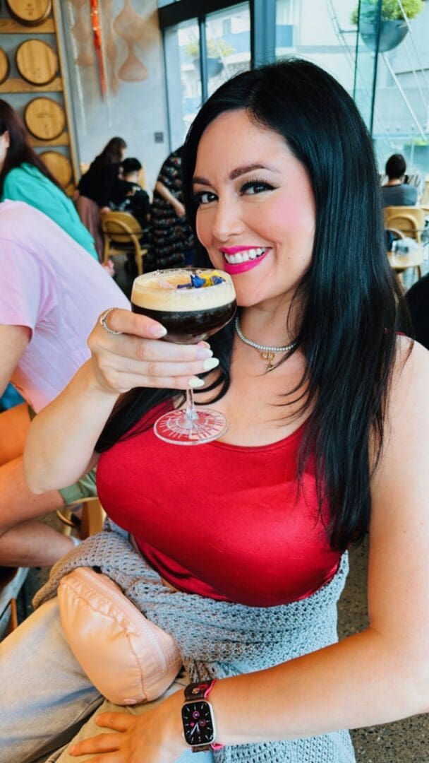 A woman holding a glass of beer in her hand.